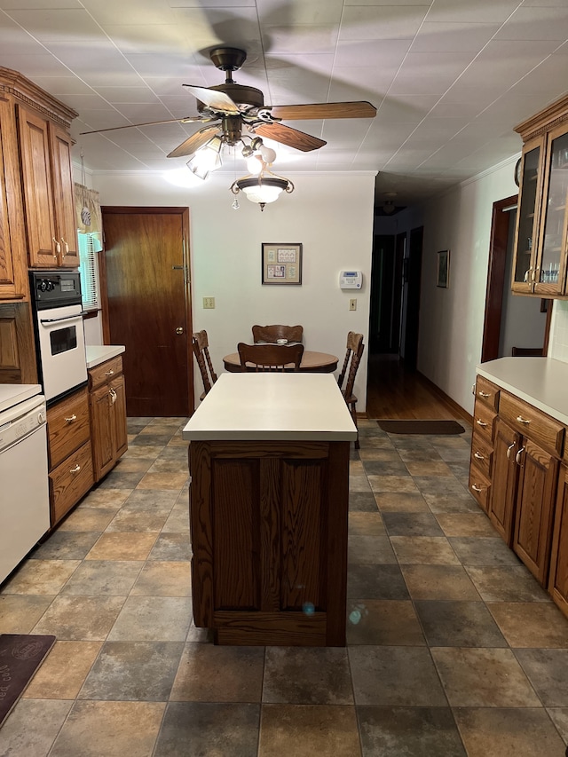 kitchen featuring white appliances, a center island, and ceiling fan