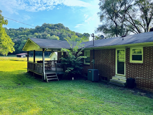 view of yard featuring central AC unit and a deck