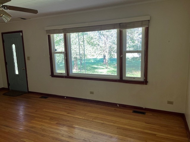 empty room featuring crown molding, ceiling fan, and hardwood / wood-style flooring