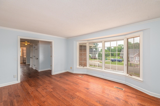 spare room featuring ornamental molding, a textured ceiling, and dark hardwood / wood-style floors