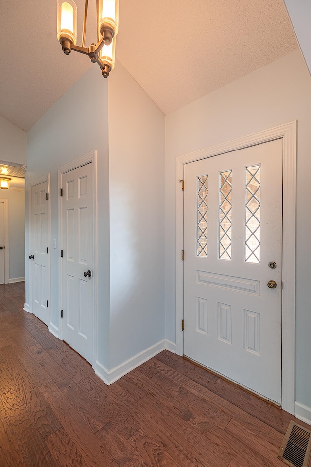 foyer with dark hardwood / wood-style floors and lofted ceiling