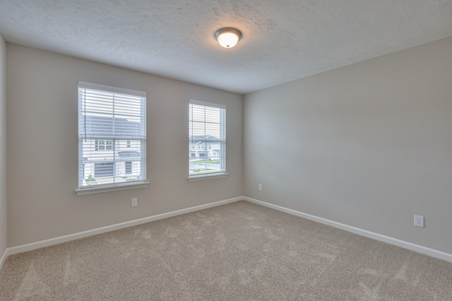 carpeted spare room featuring a textured ceiling