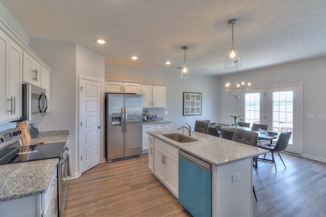 kitchen featuring hardwood / wood-style floors, stainless steel appliances, sink, a kitchen island with sink, and white cabinetry