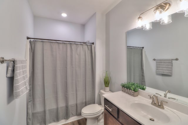 bathroom with vanity with extensive cabinet space, hardwood / wood-style flooring, and toilet