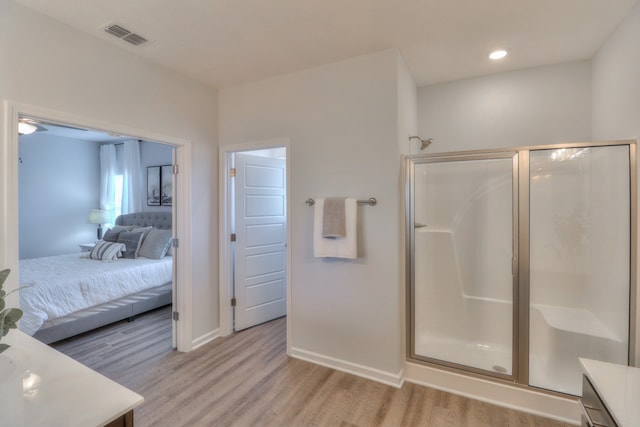 bathroom featuring a shower with door, hardwood / wood-style flooring, and vanity