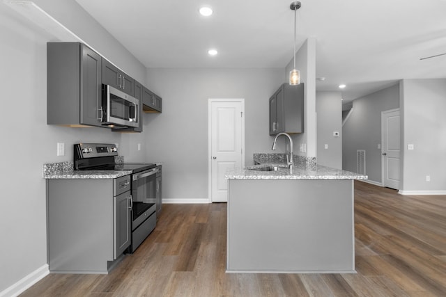 kitchen featuring sink, gray cabinetry, hanging light fixtures, light stone counters, and stainless steel appliances