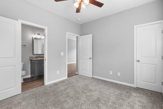 unfurnished bedroom with ceiling fan, ensuite bathroom, and carpet