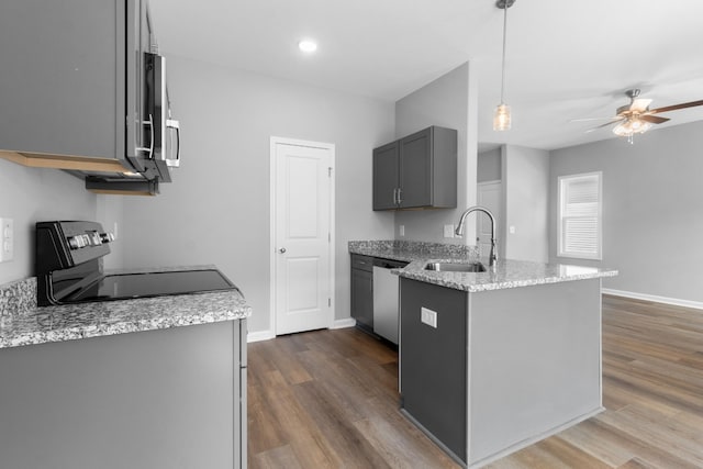 kitchen featuring pendant lighting, sink, appliances with stainless steel finishes, gray cabinetry, and light stone counters