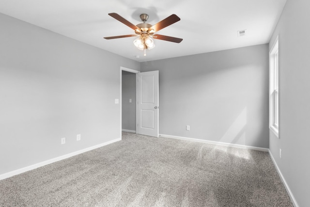 carpeted spare room with ceiling fan