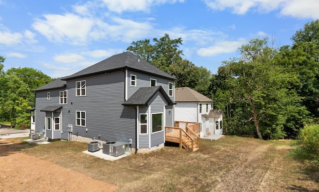 back of property with a yard and central AC unit