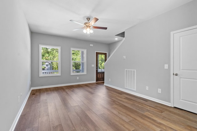 unfurnished room featuring hardwood / wood-style floors, a healthy amount of sunlight, and ceiling fan