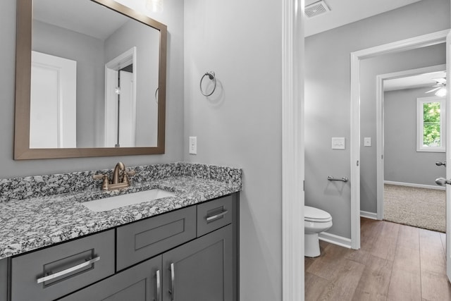 bathroom featuring vanity, ceiling fan, hardwood / wood-style flooring, and toilet