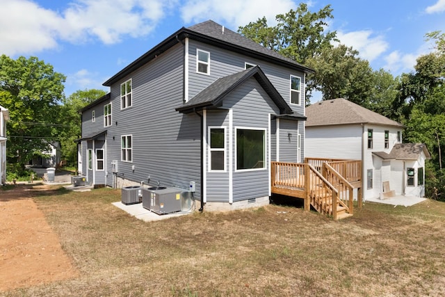 back of property featuring central AC unit and a lawn