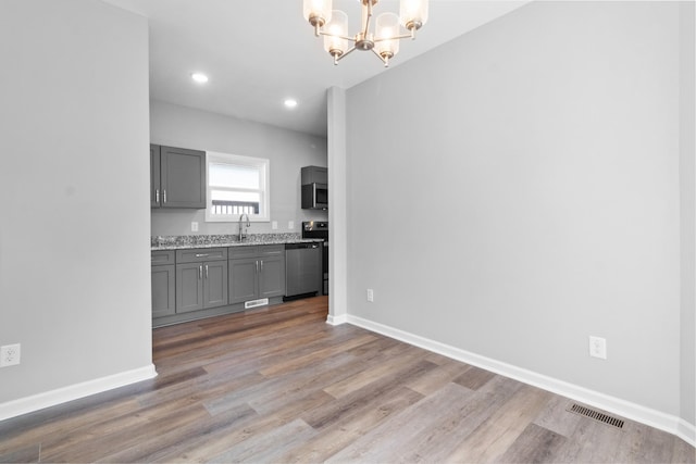 kitchen with sink, decorative light fixtures, a chandelier, gray cabinets, and stainless steel appliances