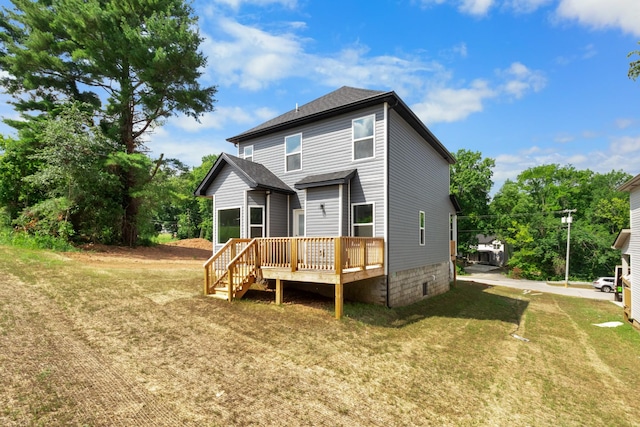 rear view of property with a wooden deck and a lawn