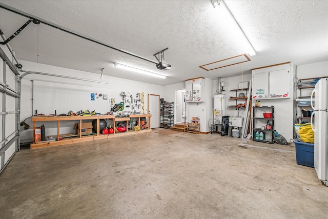 garage with white fridge, a workshop area, a garage door opener, and water heater