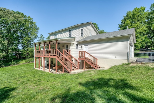 rear view of property featuring a deck and a lawn