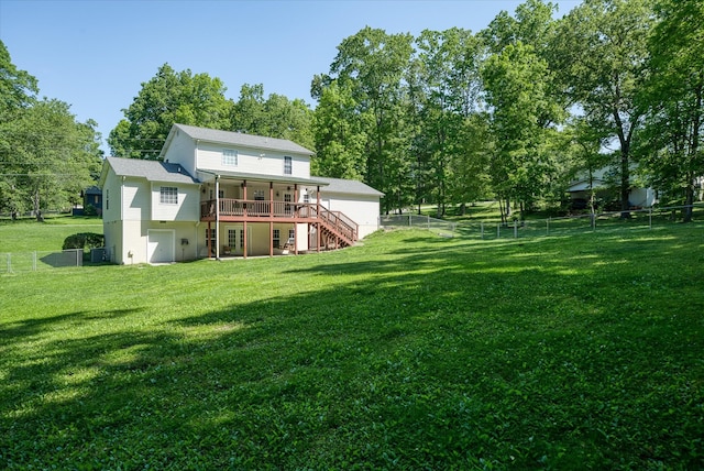 rear view of house with a deck and a lawn