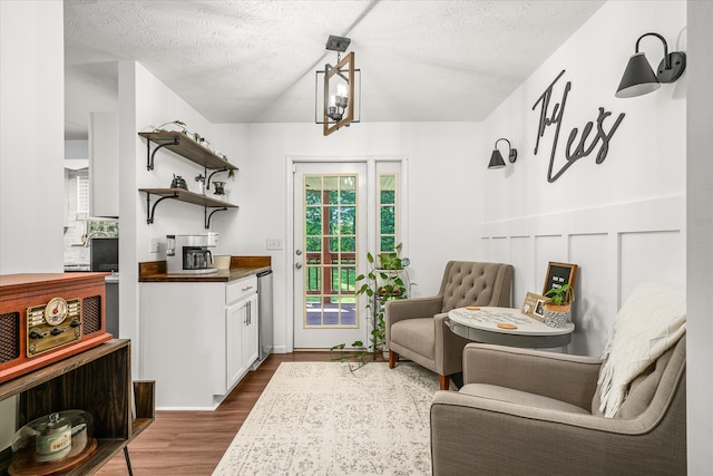 sitting room featuring dark hardwood / wood-style floors, wine cooler, and a textured ceiling