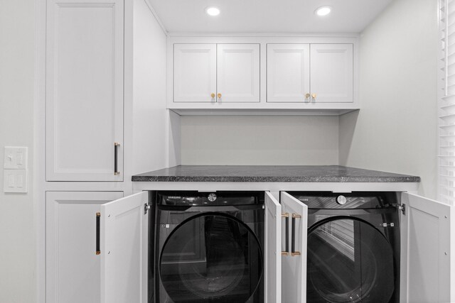 washroom featuring washer and clothes dryer and cabinets