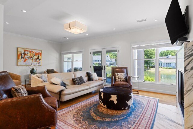 living room with ornamental molding, light hardwood / wood-style flooring, and french doors