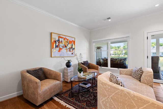 living room featuring a healthy amount of sunlight, hardwood / wood-style flooring, and crown molding