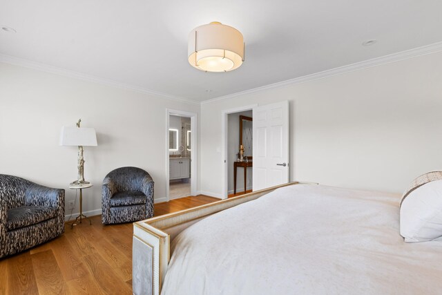 bedroom featuring hardwood / wood-style floors, ornamental molding, and ensuite bath