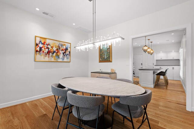 dining area featuring light hardwood / wood-style flooring and a chandelier