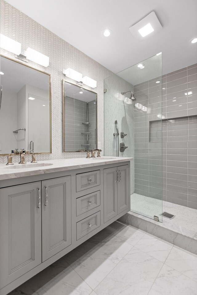 bathroom with a shower with shower door, tile floors, and dual bowl vanity