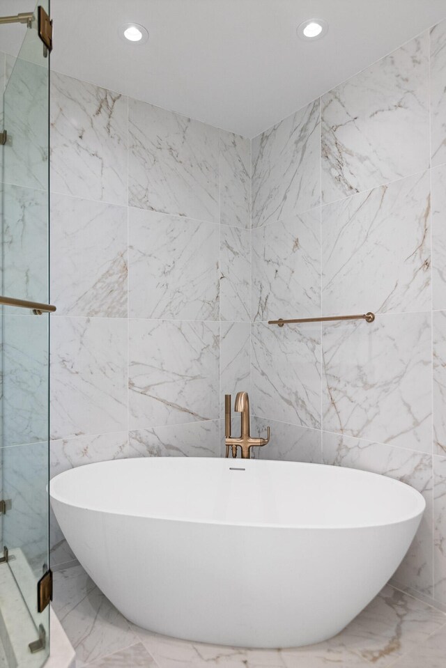 bathroom featuring tile walls, tile flooring, and plus walk in shower