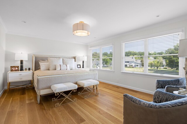 bedroom with light hardwood / wood-style floors and ornamental molding