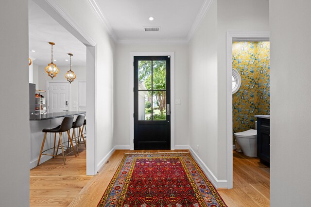 entrance foyer featuring ornamental molding and light wood-type flooring