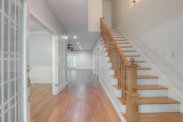 staircase with ceiling fan, light hardwood / wood-style flooring, and french doors