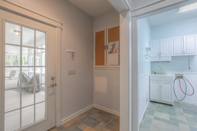 doorway to outside with tile floors and sink