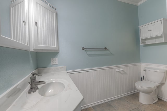 bathroom featuring tile flooring, ornamental molding, vanity, and toilet