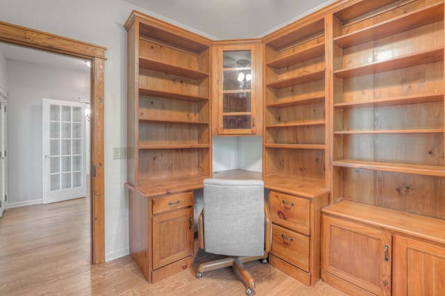 office with built in desk and light wood-type flooring