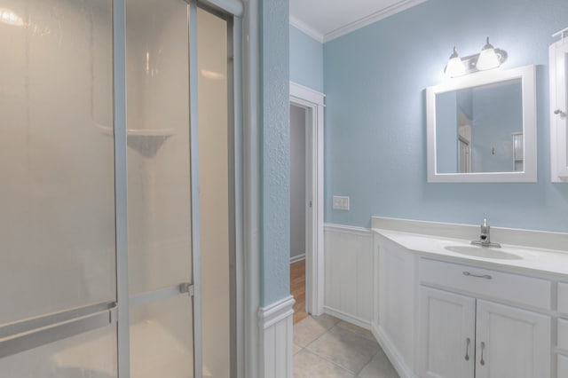 bathroom featuring walk in shower, vanity, tile floors, and ornamental molding