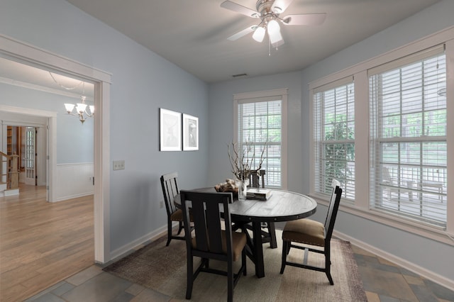 tiled dining area with ceiling fan with notable chandelier