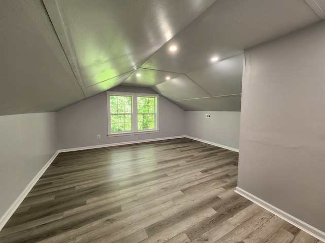 bonus room with lofted ceiling and wood-type flooring