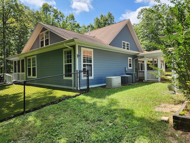 back of house featuring central AC and a yard