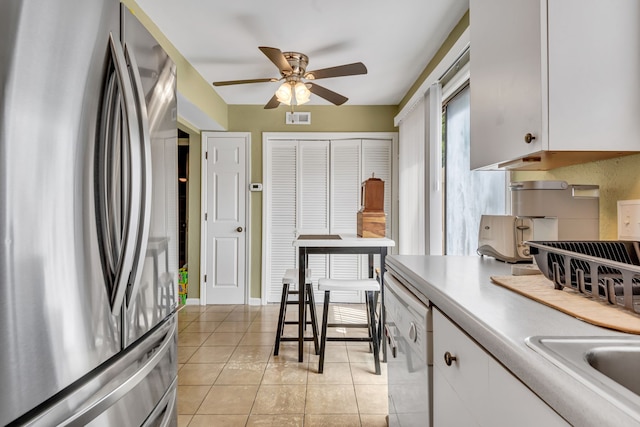 kitchen featuring ceiling fan, dishwasher, light tile floors, white cabinets, and stainless steel refrigerator