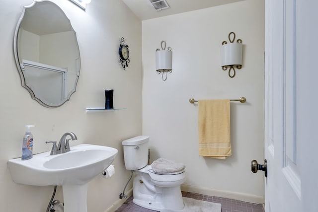 bathroom with toilet and tile floors