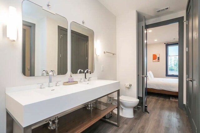 bathroom with hardwood / wood-style floors, toilet, and large vanity