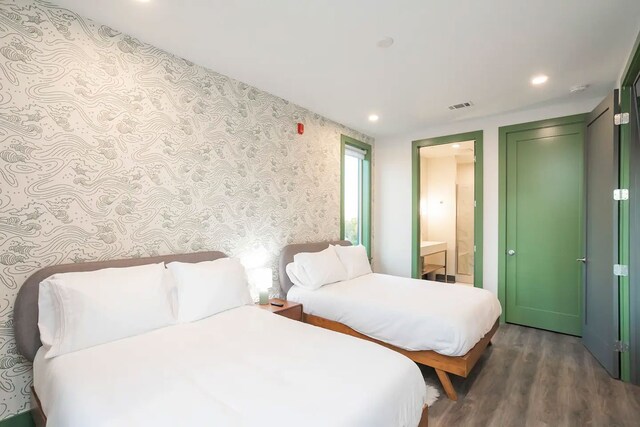 bedroom featuring dark wood-type flooring and ensuite bathroom