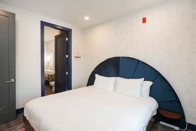 bedroom featuring dark wood-type flooring and connected bathroom