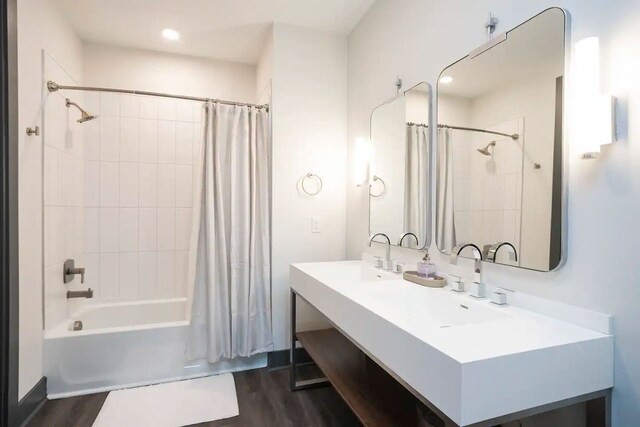 bathroom featuring vanity with extensive cabinet space, shower / tub combo with curtain, and wood-type flooring