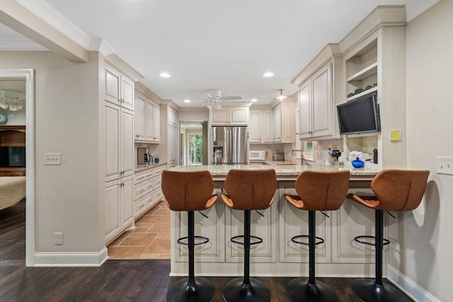 1780 Molly Hollow Rd, Nolensville, TN 37135 - kitchen featuring a breakfast bar, ornamental molding, tasteful backsplash, light stone counters, and stainless steel fridge with ice dispenser