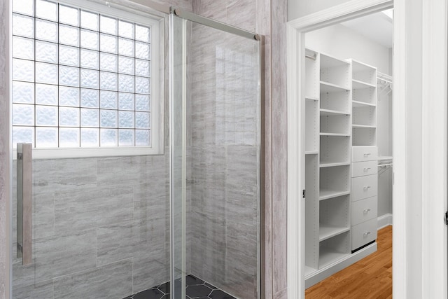 bathroom featuring a shower with shower door and wood-type flooring