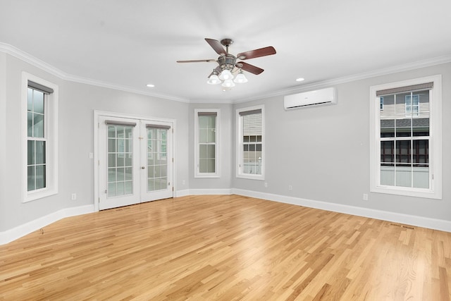 spare room with a wall mounted air conditioner, french doors, ceiling fan, crown molding, and light hardwood / wood-style floors