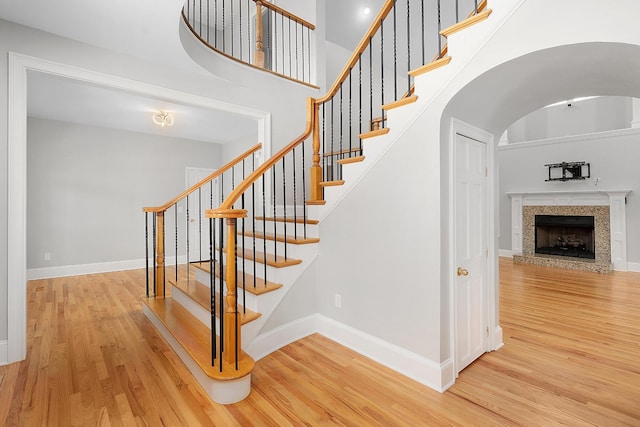 stairs featuring wood-type flooring and a towering ceiling